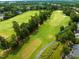 Aerial view of the lush green golf course, complete with sand traps and manicured fairways at 10400 Rosegate Ct # 3, Raleigh, NC 27617