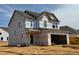 Two-story home under construction showcasing a modern design with a covered porch and attached garage at 1049 Channel Drop Lp, Zebulon, NC 27597