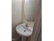 A charming powder room featuring a pedestal sink and decorative mirror at 11711 Mezzanine Dr # 109, Raleigh, NC 27614