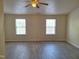 Bright, neutral bedroom featuring luxury vinyl plank flooring, ceiling fan, and large windows at 11711 Mezzanine Dr # 109, Raleigh, NC 27614