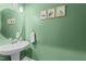 A half bathroom featuring a pedestal sink, modern fixtures, and green paint at 118 Lockhaven Dr, Garner, NC 27529