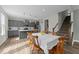 Bright dining room leading to the kitchen with gray cabinets and a staircase to the upper level at 118 Lockhaven Dr, Garner, NC 27529