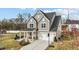 Charming two-story home with gray siding, a front porch, a two-car garage, and a basketball hoop on a concrete driveway at 118 Lockhaven Dr, Garner, NC 27529