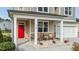 Charming front porch with a red door, seating, and stone accents enhance curb appeal at 118 Lockhaven Dr, Garner, NC 27529