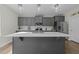 This kitchen features grey cabinets, stainless steel appliances, and a large island with sink and modern fixtures at 118 Lockhaven Dr, Garner, NC 27529