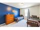 Bedroom with blue accent wall, two twin beds, dresser, and a bright window at 1253 Manor Dr, Rocky Mount, NC 27804