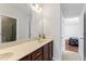 Bathroom with double sinks, a large mirror, vanity cabinets, and a view into an adjacent bedroom at 12812 Baybriar Dr, Raleigh, NC 27613