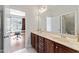 Bathroom featuring double sinks, a large mirror, vanity cabinets, and a view into an adjacent office at 12812 Baybriar Dr, Raleigh, NC 27613