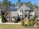 Inviting two-story home featuring stone accents, solar panels, a landscaped yard, and manicured shrubbery at 12812 Baybriar Dr, Raleigh, NC 27613