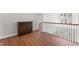 Upstairs hallway with wood floors, dark wood furniture, and railing with black spindles at 12812 Baybriar Dr, Raleigh, NC 27613