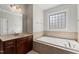 Bright main bathroom features double sink vanity, soaking tub and tiled window at 12812 Baybriar Dr, Raleigh, NC 27613