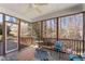 Screened porch with a ceiling fan, a table with chairs, and a view into the wooded backyard at 12812 Baybriar Dr, Raleigh, NC 27613
