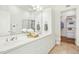 Elegant bathroom featuring a double vanity, stylish mirrors, a glass-enclosed shower, and a glimpse into a walk-in closet at 1309 Langdon Pl, Pittsboro, NC 27312