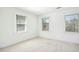 Bright bedroom with three windows offering ample natural light, carpet flooring and neutral white walls at 1309 Langdon Pl, Pittsboro, NC 27312