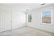 This bright bedroom has two windows, a door, and neutral-colored walls and carpet at 1309 Langdon Pl, Pittsboro, NC 27312