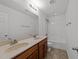 Bathroom featuring double sinks with a large mirror, tub, shower, and vinyl flooring at 1445 Lombar St, Raleigh, NC 27610