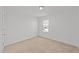 Bright, carpeted bedroom featuring natural light from a large window at 1445 Lombar St, Raleigh, NC 27610