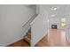 Bright entryway featuring hardwood floors, a staircase, and a glimpse into the open-concept living area at 1445 Lombar St, Raleigh, NC 27610