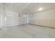 Spacious two-car garage featuring high ceilings, concrete floors, and an automatic door opener at 1445 Lombar St, Raleigh, NC 27610