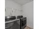 Laundry area features modern, dark appliances and overhead shelving at 1445 Lombar St, Raleigh, NC 27610