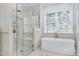 Elegant primary bathroom featuring marble floors, soaking tub, and glass shower at 1925 Banbury Rd, Raleigh, NC 27608