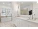 Elegant primary bathroom featuring marble floors, double vanity, soaking tub, and glass shower at 1925 Banbury Rd, Raleigh, NC 27608