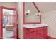 Bright, pink-themed bathroom with patterned wallpaper and a view into the bedroom at 1925 Banbury Rd, Raleigh, NC 27608