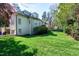 Rear exterior of a white brick home featuring a large lawn and mature landscaping at 1925 Banbury Rd, Raleigh, NC 27608