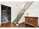 Bright foyer with staircase, hardwood floors, and partial view into the luxurious home office at 1925 Banbury Rd, Raleigh, NC 27608