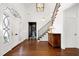Grand foyer featuring hardwood floors, staircase, entry doors, and glimpse into the home office at 1925 Banbury Rd, Raleigh, NC 27608