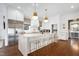 Open kitchen featuring a large island with counter seating, stainless steel appliances, and custom cabinetry at 1925 Banbury Rd, Raleigh, NC 27608