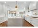 Bright kitchen featuring a large kitchen island, white cabinets, hardwood floors, and modern lighting at 1925 Banbury Rd, Raleigh, NC 27608