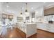 Bright, modern kitchen featuring white cabinets, waterfall island, gold accents, and stainless steel appliances at 1925 Banbury Rd, Raleigh, NC 27608