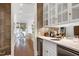 Charming wet bar with elegant cabinets, countertop, wine cooler, and a view into the seating area at 1925 Banbury Rd, Raleigh, NC 27608