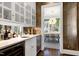 Stunning wet bar featuring stylish cabinetry, countertop, wine refrigerator and view into dining room at 1925 Banbury Rd, Raleigh, NC 27608