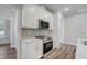 Modern kitchen with stainless steel appliances and white cabinets with gray backsplash at 195 Duncan Creek Rd # 123, Lillington, NC 27546