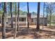 Backyard with a brick chimney, screened porch, and surrounded by tall trees at 2 Edgestone Pl, Chapel Hill, NC 27517