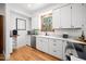 Bright kitchen featuring white cabinets, stainless steel appliances, and hardwood floors at 2 Edgestone Pl, Chapel Hill, NC 27517