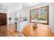 Kitchen with white cabinets, island, stainless steel appliances, wood-framed windows, and breakfast table at 2 Edgestone Pl, Chapel Hill, NC 27517