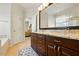 Elegant primary bathroom featuring a double vanity, granite countertop, and large mirror at 2006 Prairie Ridge Ct, Fuquay Varina, NC 27526