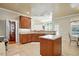 Well-lit kitchen with wooden cabinetry, island, stainless steel appliances, and tile flooring at 2006 Prairie Ridge Ct, Fuquay Varina, NC 27526
