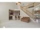 Spacious living room with staircase, views into the kitchen, and neutral color palette at 2006 Prairie Ridge Ct, Fuquay Varina, NC 27526