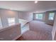 View of carpeted bonus room with natural light from windows overlooking the neighborhood at 217 Duncan Creek Rd # 124, Lillington, NC 27546