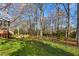 A beautiful backyard with mature trees, a green lawn, and a charming seating area at 2203 Canterbury Dr, Burlington, NC 27215