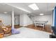 Finished basement featuring a ping pong table, white-painted brick walls and ceiling tiles at 2203 Canterbury Dr, Burlington, NC 27215