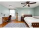 A light green bedroom featuring hardwood floors, a bed, and a desk at 2203 Canterbury Dr, Burlington, NC 27215