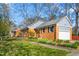 Charming brick home featuring mature trees and a well-maintained lawn with attached garage at 2203 Canterbury Dr, Burlington, NC 27215