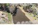 Stunning aerial view of a tranquil pond surrounded by lush greenery and mature trees at 248 Brookfield Cir, Sanford, NC 27330