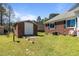 Backyard view featuring a brick storage building on a well-maintained lawn at 248 Brookfield Cir, Sanford, NC 27330