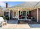 Covered front porch with seating area with a brick home and well-kept front yard at 248 Brookfield Cir, Sanford, NC 27330